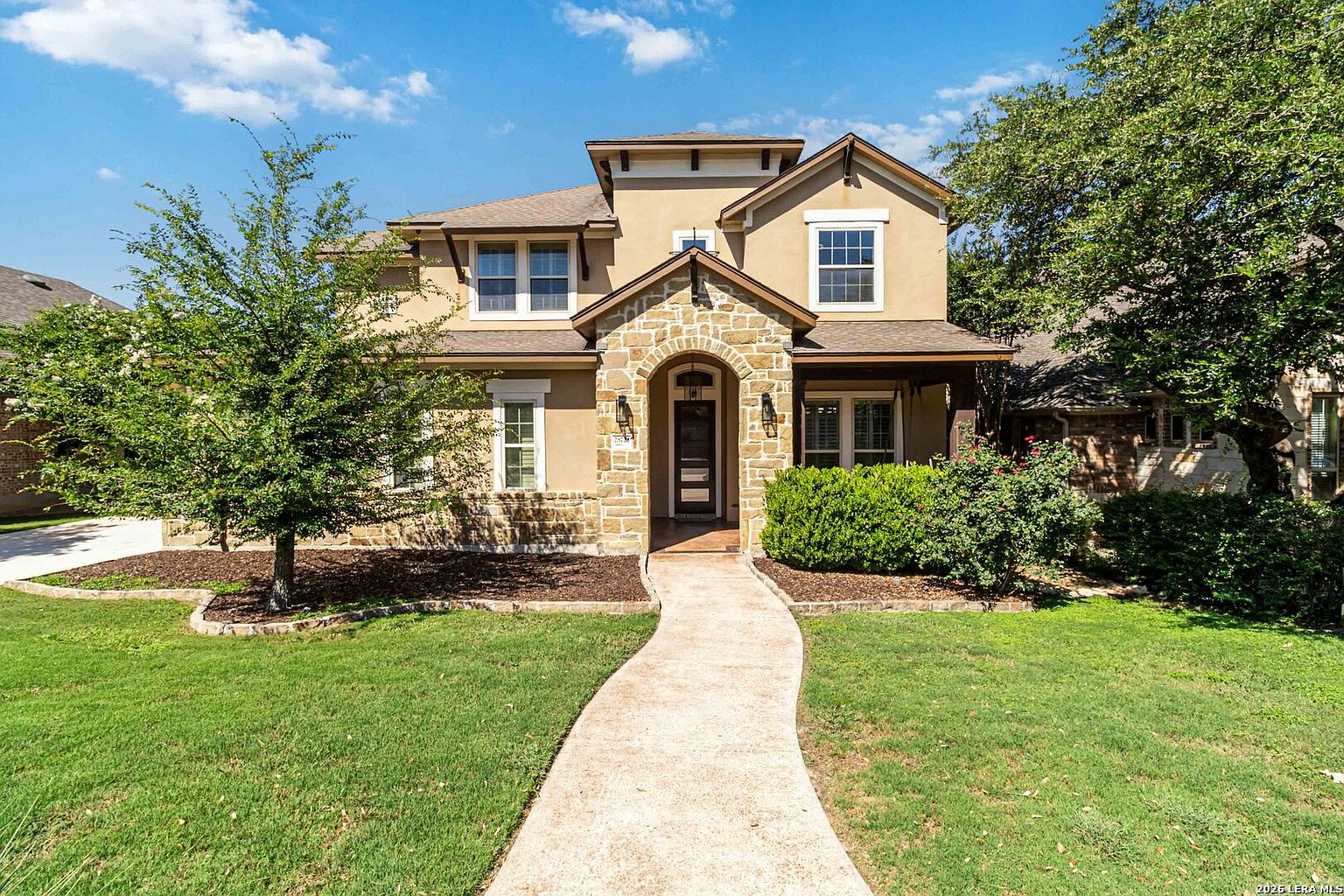 The walkway approach to 28722 Front Gate, the path crossing a manicured lawn to the limestone-framed front door